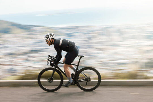 Fitness, bike or cyclist outdoor with motion blur, endurance training or speed in cardio workout. Fast, space or male person on road with bicycle, physical activity or riding practice in sport hobby.