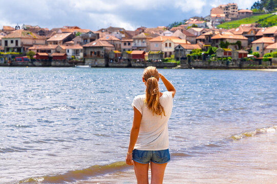 tourist woman looking at the traditional horreos and coastal village of Combarro, Galicia, Travel destination, tour tourism in Spain