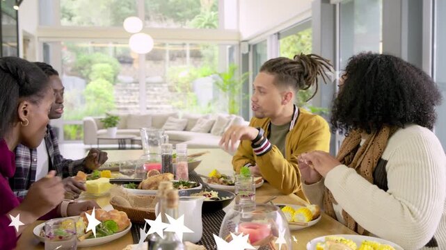 Camera pulling back, group passing dishes and talking for food shoot, stars overlaying lower frame