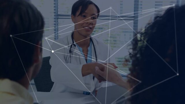 Doctor explaining and gesturing, handing paper across desk to share during consult, network overlay