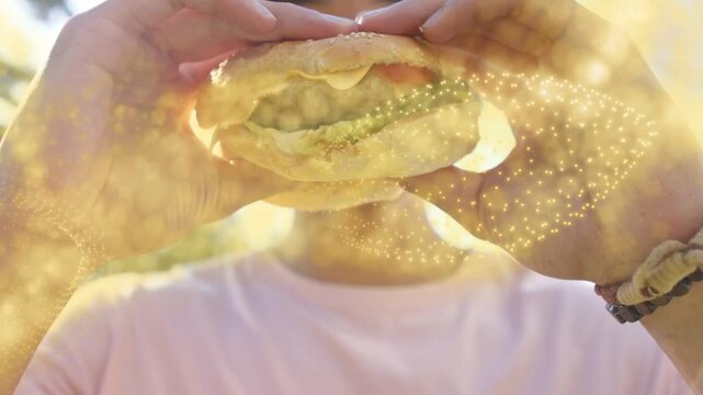 Man holding sandwich to camera for food, bringing forward and biting, golden overlay crossing hands