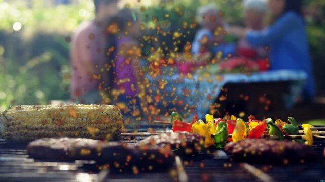 Barbecue grill sending embers after oil spitting, corn steaming, patties darkening for family meal