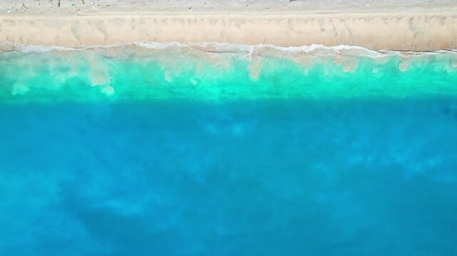 Aerial drone footage from above of the magnificent Kolbano beach, in South Central Timor regency, Indonesia, with its blue azur unique sea water, white and multicolor beach stones, waves