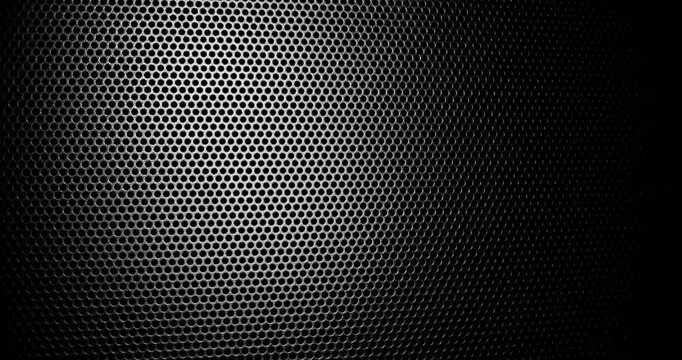 Black Perforated Metal Mesh. Smooth slow movement across extreme close-up of dark perforated metal grid with dramatic side lighting.