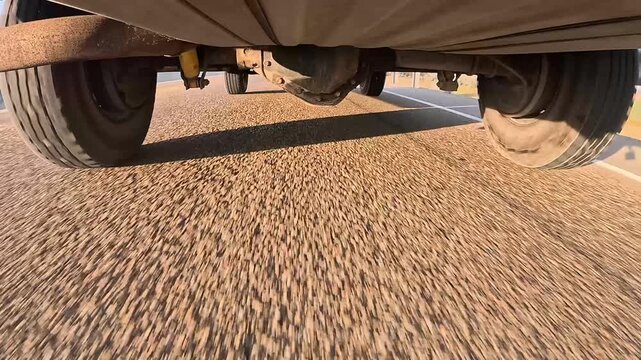 Low-angle shot shows vehicle wheels moving forward