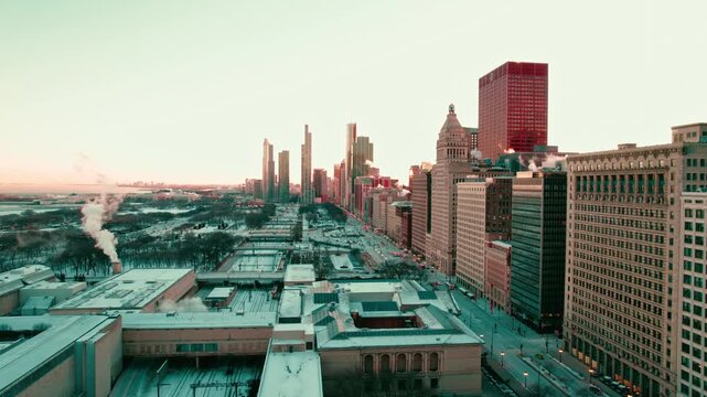 Aerial view of Chicago skyline at sunrise during cold winter morning with snow covered rooftops and urban architecture.
