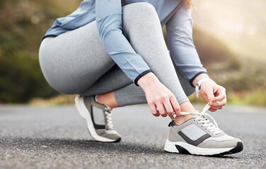 Obraz premium Hands, tying laces and shoes of runner outdoor for fitness start, health and training sneakers. Wellness, exercise and sports athlete and feet of person in street for getting ready and preparation