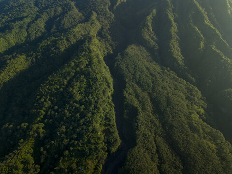 Aerial view of the lush green volcanic slopes and deep ravines near Bunker Kaliadem Merapi in Kecamatan Pakem, Daerah Istimewa Yogya, Indonesia.