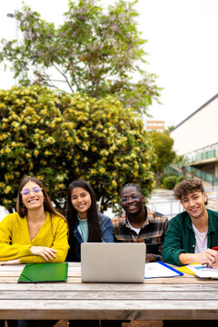 University students studying together outdoors with laptop