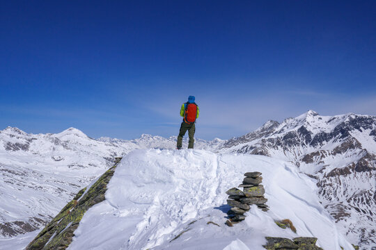 Alpinista contempla il paesaggio dalla vetta della montagna