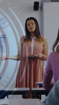 Vertical video: Teen presenter raising tablet and speaking in classroom, activating HUD overlays