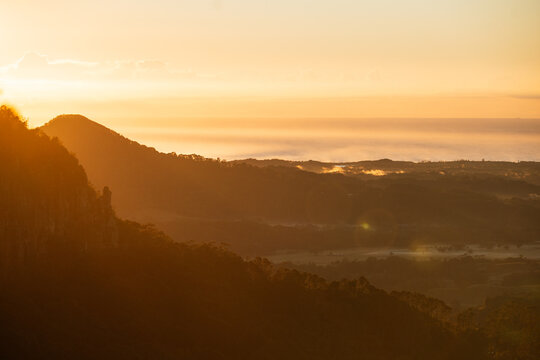 Golden hour sunrise over layered mountains and mist