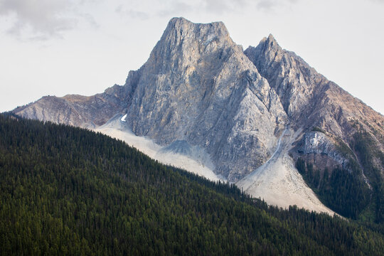 Rugged Mountain Peak Rising Above Dense Evergreen Forest Landsca