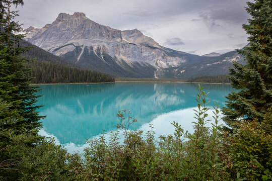 Turquoise Mountain Lake Framed by Evergreen Forest and Rocky Pea