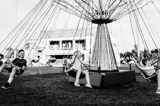 Kids laughing midair on carnival swing ride
