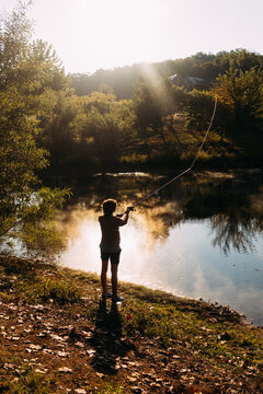 Child fishing alone in warm sunrise light