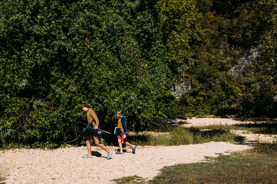 Kids walking with fishing gear on trail