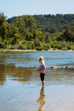 Child fishing in shallow river in Ozarks