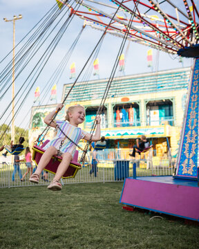 Joyful child soaring on carnival swing ride