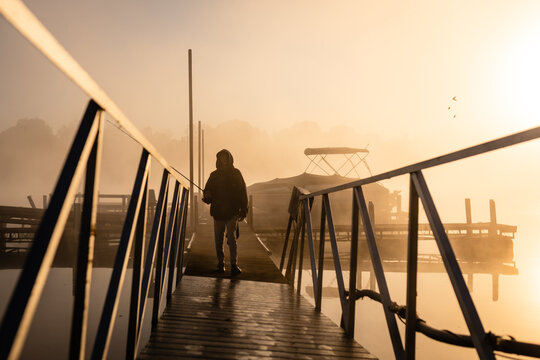 Boy Fishing on Misty Lake Dock