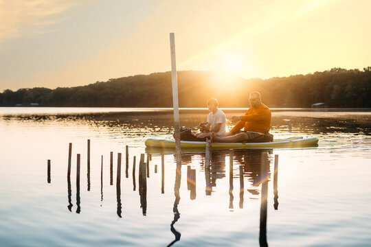 Father and son fishing around fish habitat at sunset