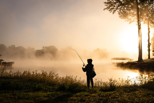 Young Fisherman Casting at Foggy Sunrise