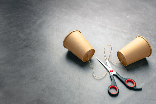 Broken communication and social disconnection concept with cut string phone