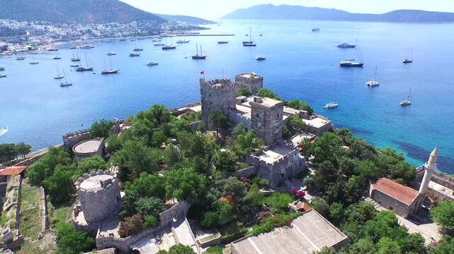 Aerial Bodrum Castle above marina and sea boats on Turkeys Aegean and Mediterranean coast. Turquoise harbor borders an ancient walled citadel as yachts gather beside the sunlit coastal city.