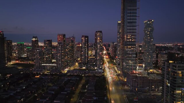Stunning aerial hyperlapse captures vibrant city life at dusk, showcasing downtown core with illuminated skyscrapers and bustling traffic flow.