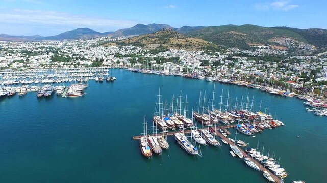 Aerial Bodrum Castle above marina and sea boats on Turkeys Aegean and Mediterranean coast. Turquoise harbor borders an ancient walled citadel as yachts gather beside the sunlit coastal city.