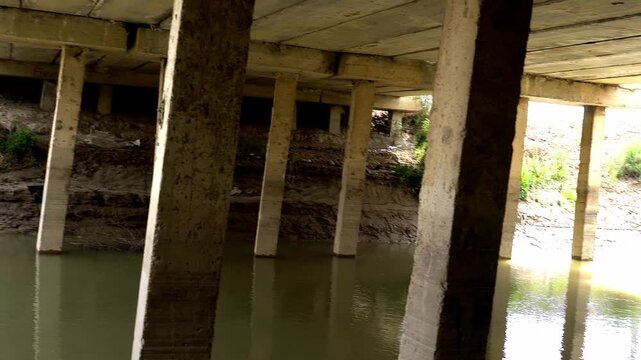 Concrete bridge supports over the water of an irrigation canal.