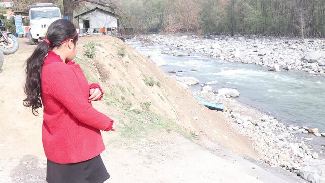 Raw video footage of a young kid standing near a flowing river in Manali Himachal Pradesh India showcasing mountain landscape travel and outdoor adventure.