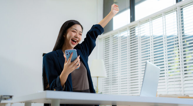 Overjoyed charming excited woman business woman worker using smartphone.