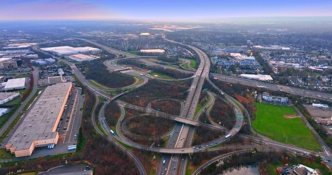 Transport goes by the complicated system of roads. Lively interchange across the wooded landscape from drone.