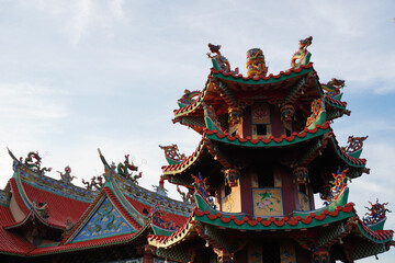 Fototapeta premium Intricate architecture of a Chinese temple roof with detailed dragon sculptures.