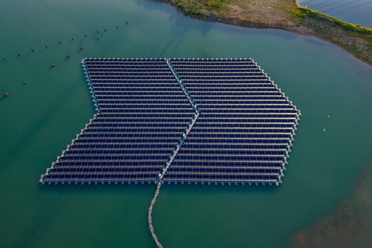 Aerial view of floating solar panel array on a calm lake Bensheim, Hessen, Germany.