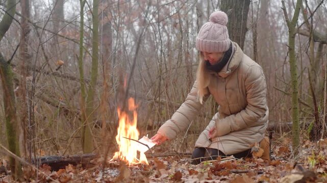 Happy young woman destroying old diary in fire, starting new life Symbolic farewell and emotional release. Destruction of sensitive information in isolation.