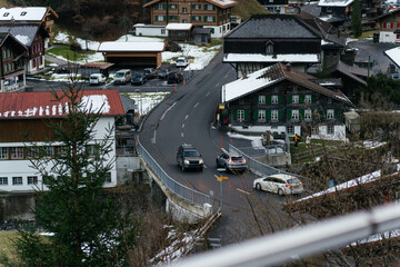 Scenic alpine village with traditional houses and green pastures set against dramatic mountains and rocky cliffs in a peaceful rural landscape. © Христя Сидор