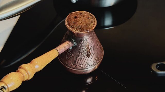 Home barista making traditional Turkish coffee. Closeup of cezve boiling coffee with rich aroma