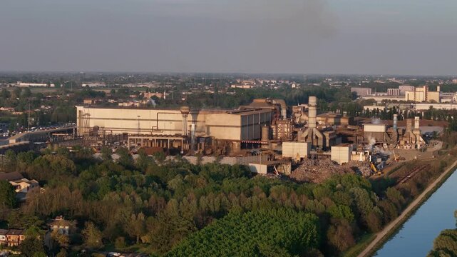 Acciaieria Arvedi steelworks Spinadesco Cavatigozzi Cremona Lombardy Italy with electric arc furnace plant beside Canale Milano Cremona Po and Po Valley farmland, drone slow pullback shot