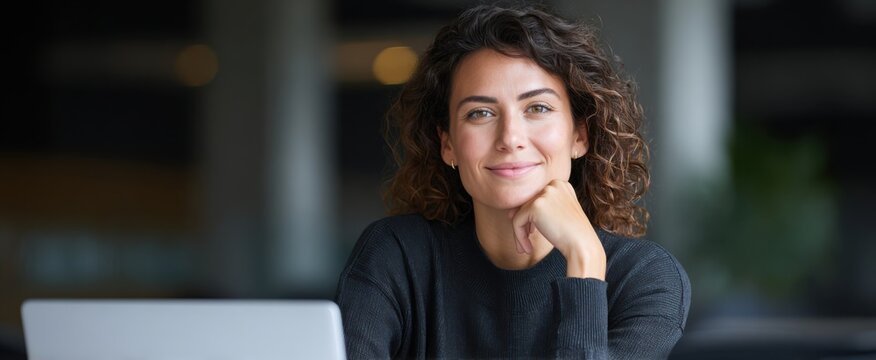 Confident young female entrepreneur at her tech oasis beaming at the camera with success.