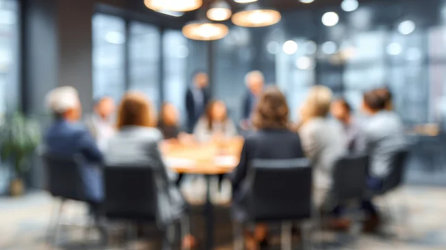 Professional business team members sitting together around a wooden table during a corporate office meeting session