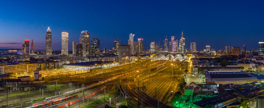 Aerial view of the Hauptbahnhof central station and the illuminated skyline with skyscrapers under a twilight sky Frankfurt am Main, Hessen, Germany.