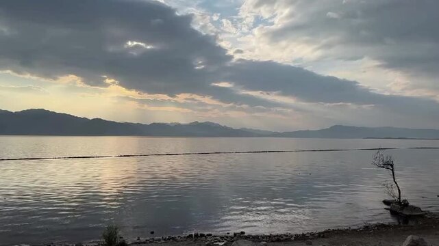 Beautiful sun rays breaking through clouds over Dianchi Lake with mountain silhouettes in Kunming Yunnan China