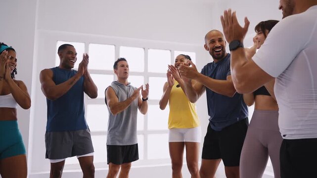 Diverse group of athletes sharing triumphant moment, celebrating successful workout with warm embrace, radiating team spirit and mutual support
