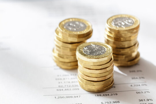Stack of pound coins on financial figures background