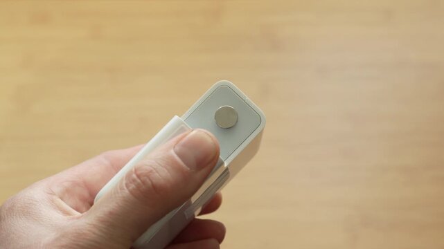 Close up of male hands connecting European power plug to power adapter. Concept of electricity connection, device setup, power supply and compatibility.