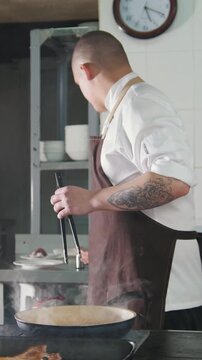 The cook adds spices and onion to food