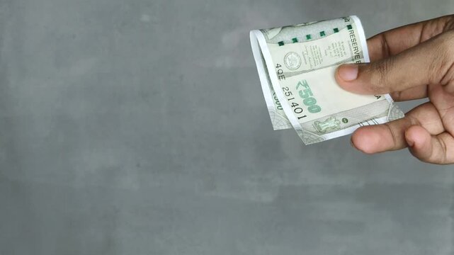 Hand buying pack of cocaine or heroin powder and paying indian rupee money to dealer who selling narcotic substance. Drug sale, trade, smuggling, distribution and trafficking business in India concept