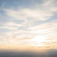 Fototapeta premium Beautiful sunset sky with soft clouds over a distant mountain range landscape